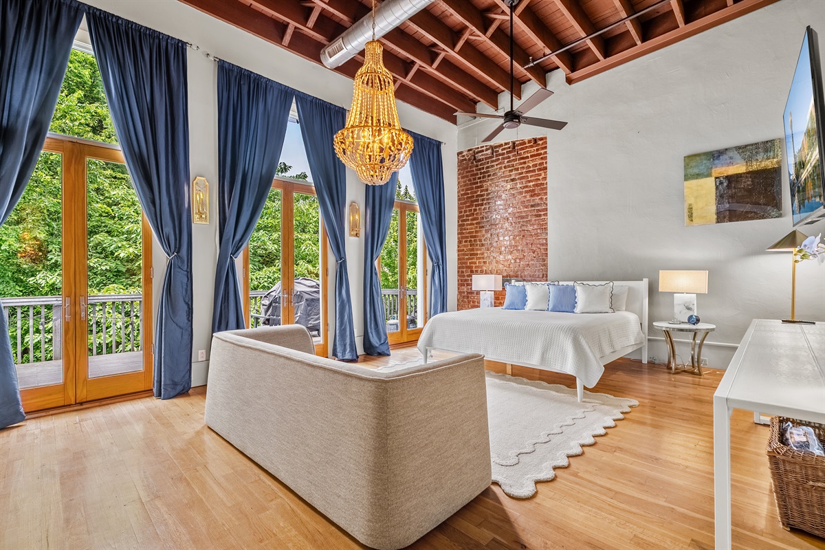Master bedroom with king bed, private balcony, lounge seating, and ensuite bathroom.