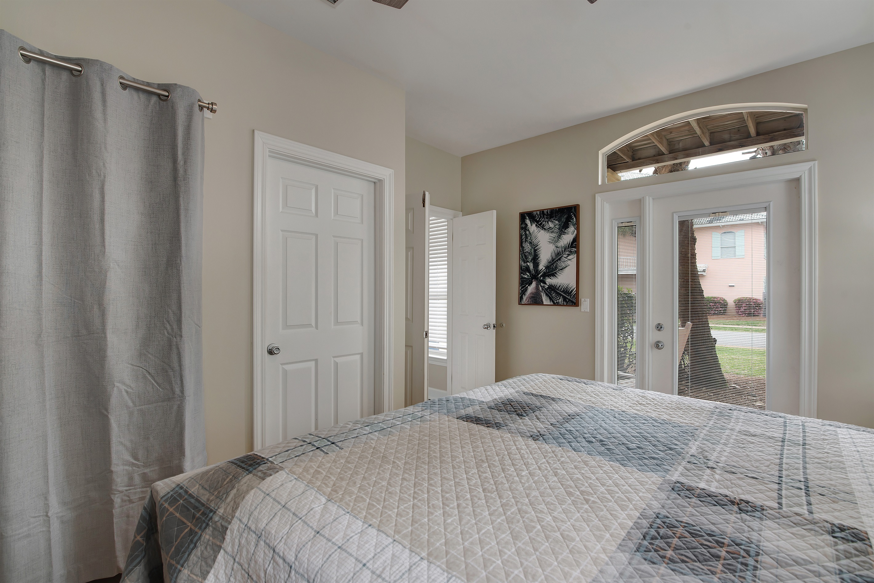  King bedroom with coastal bedding and natural light