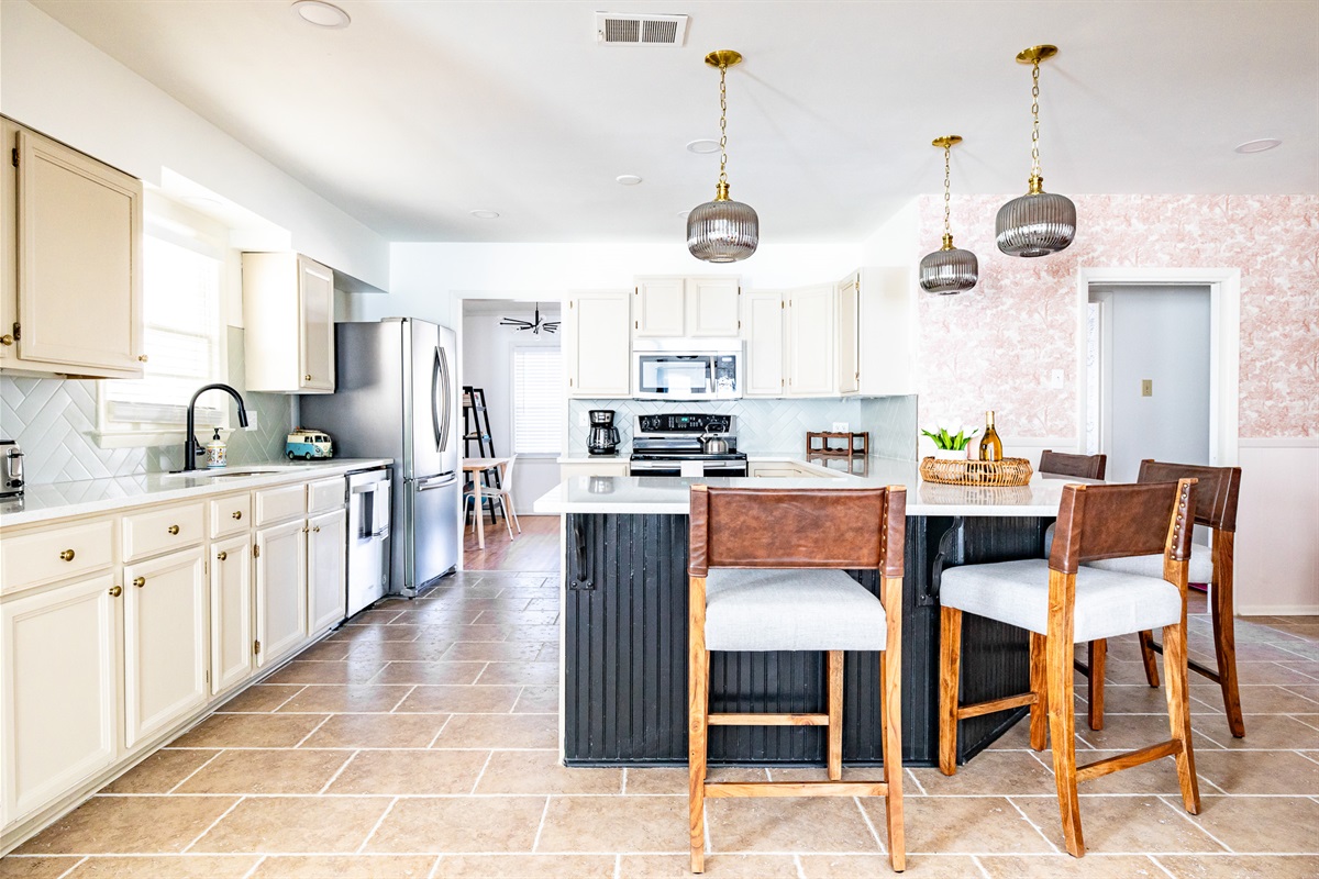 Large kitchen features large stainless steel refrigerator.