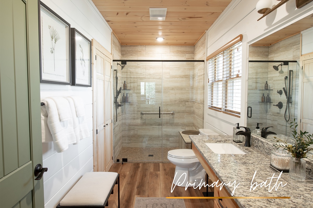 Bathroom 1 offers spa-like convenience with dual vanities, natural wood finishes, and a walk-in shower to start your day right.