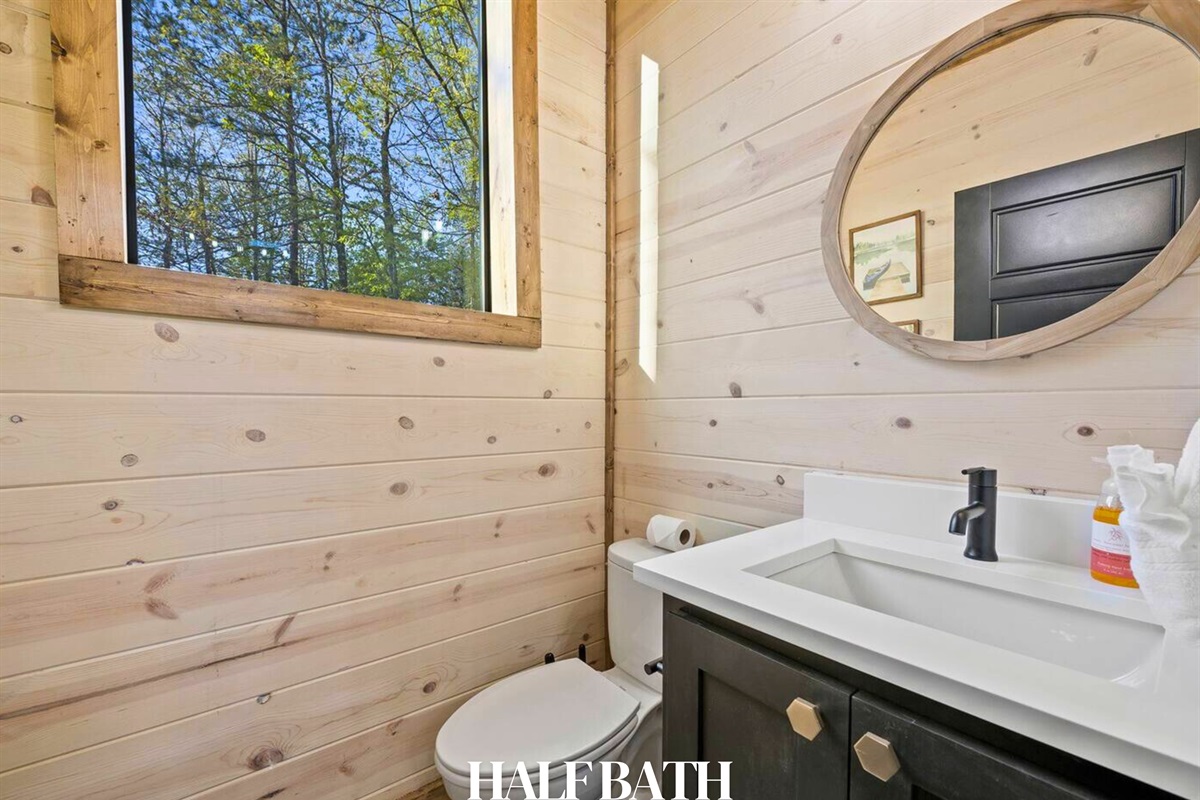 Convenient, main floor half bath with natural wood walls and a bright vanity.