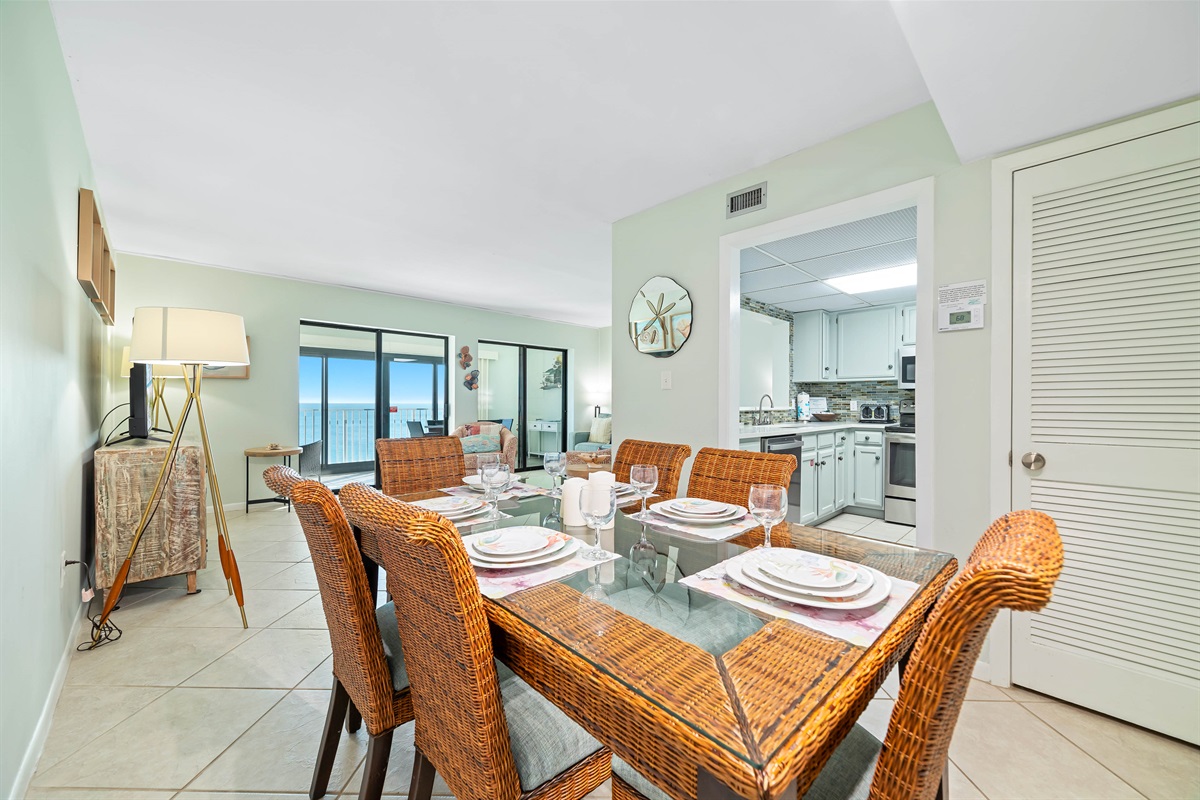 Elegant dining set with wicker chairs and a glass-top table, creating a warm and sophisticated atmosphere.