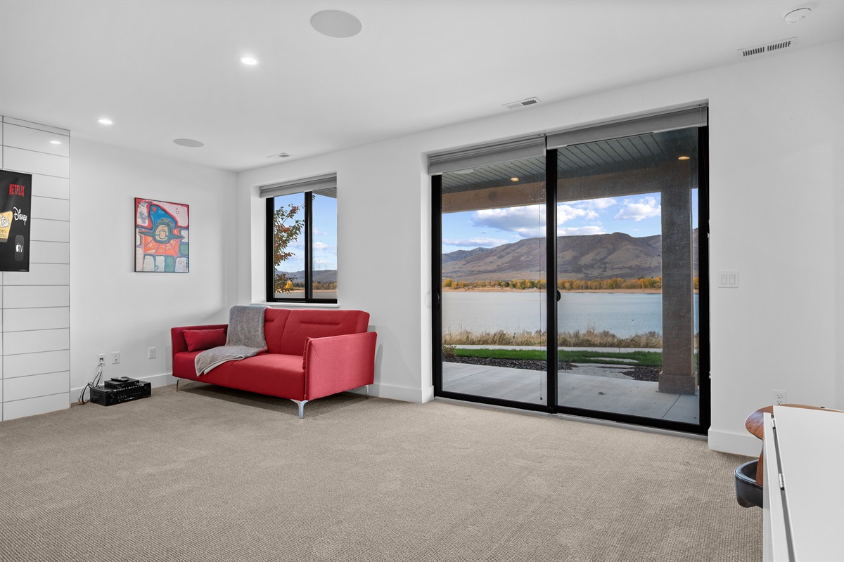 Bright secondary living space with seating area and panoramic lake views.