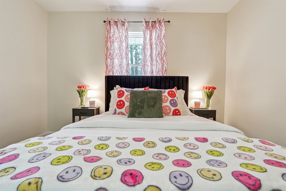 A comfortable bedroom featuring a bed, a ceiling fan, a window, a TV, and a closet — a cozy space to rest and relax.

