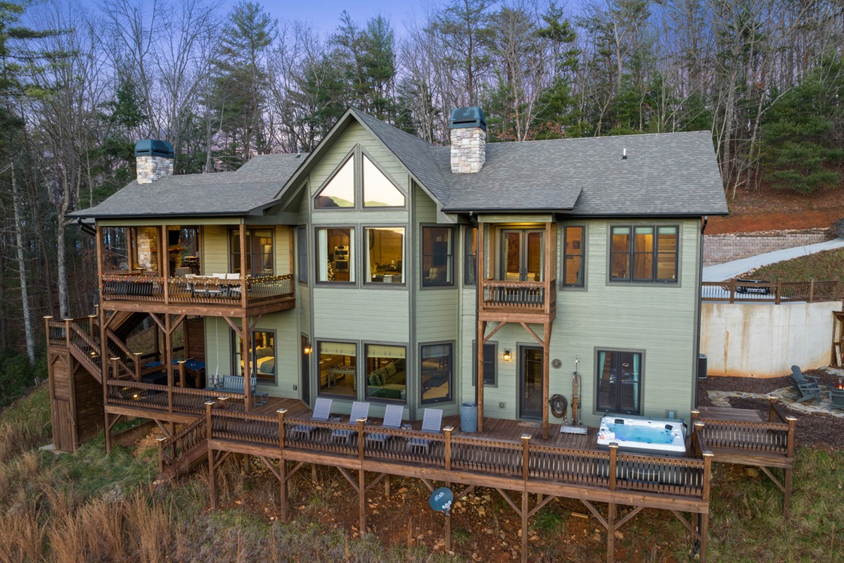 A view of the chalet's rear exterior, showcasing multiple decks and stunning mountain views.