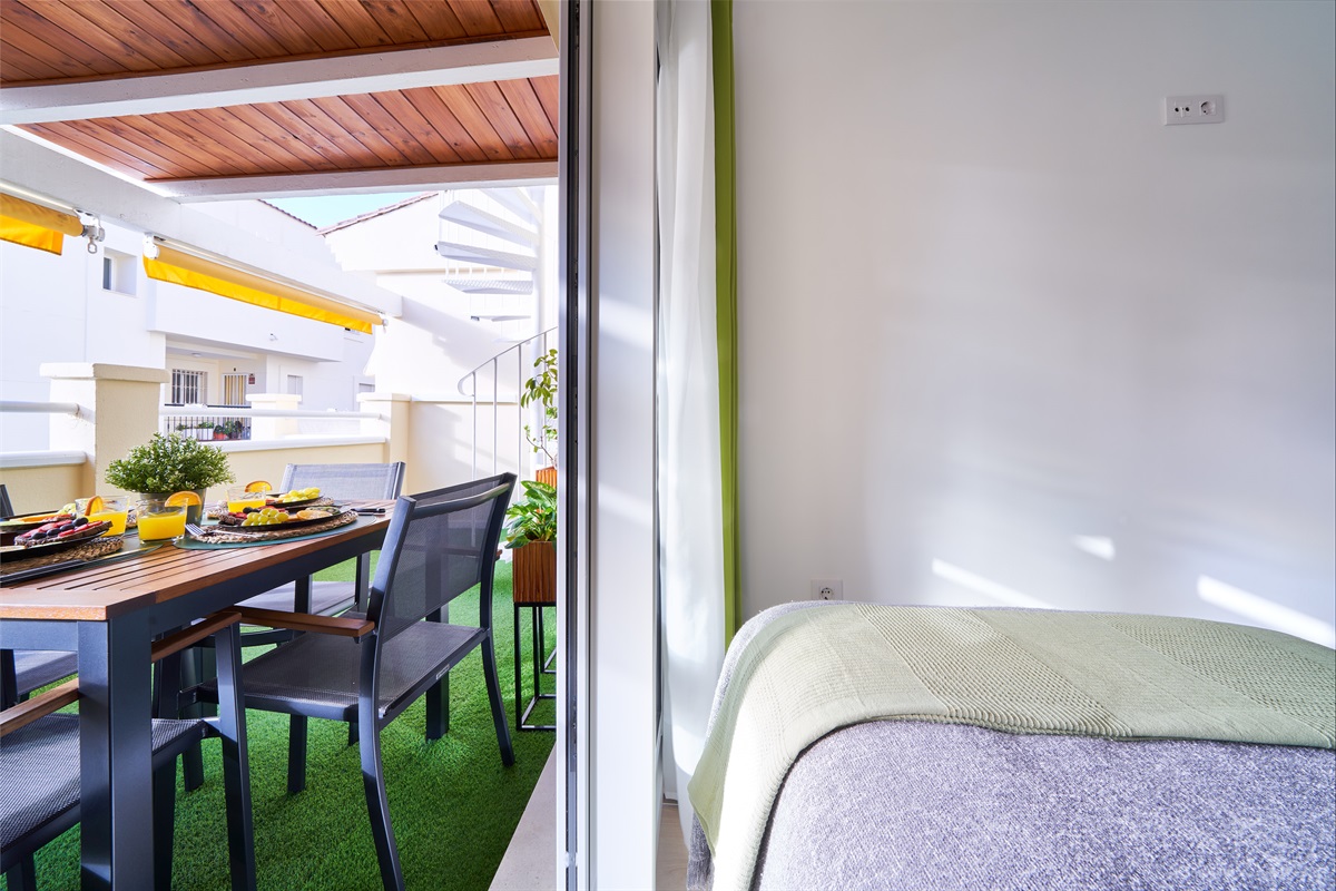 Bright and calming twin bedroom with tropical tones, soft linens, and direct access to the terrace - perfect for relaxed mornings and restful nights.