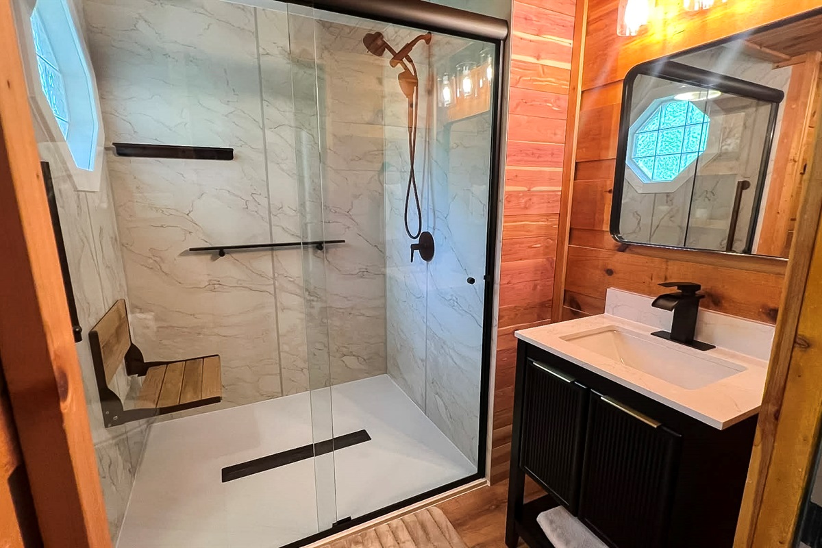 Tiled, walk in shower with teak wood bench