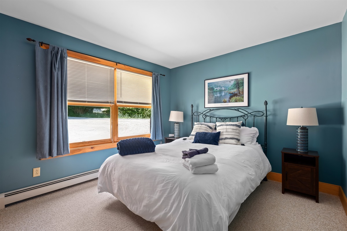 Relax in this tranquil bedroom with soothing blue tones, soft natural light, and a plush bed perfect for deep, uninterrupted sleep.