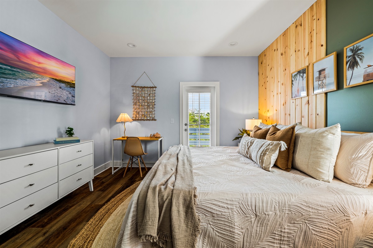 Comfort meets convenience. This spacious bedroom features cozy bedding and a small workspace for guests who need to check in before heading back to the beach.