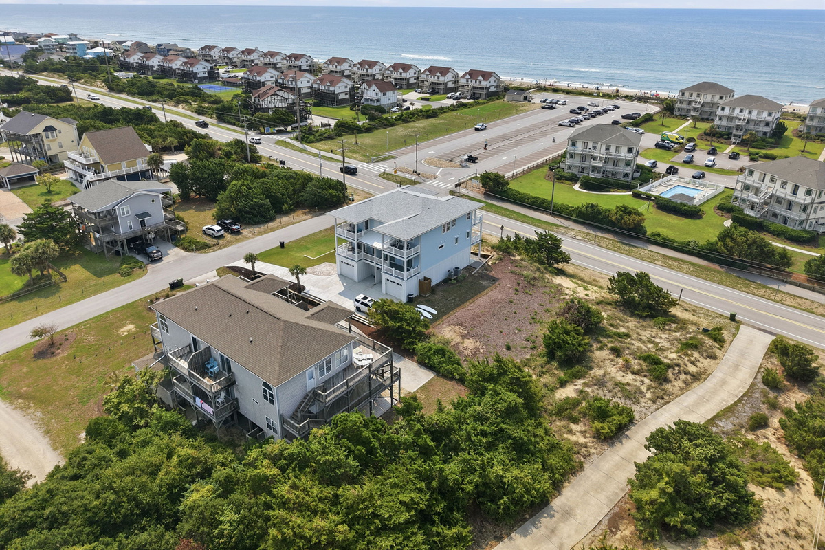 Wide aerial perspective showing the short distance to the ocean beach access, sound-side views, and surrounding coastal community