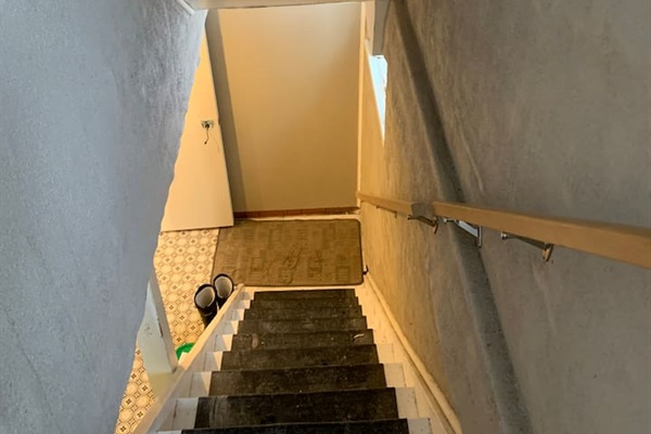 Shared downstairs stairway to the shared laundry room located outside of the private main-floor suite. 