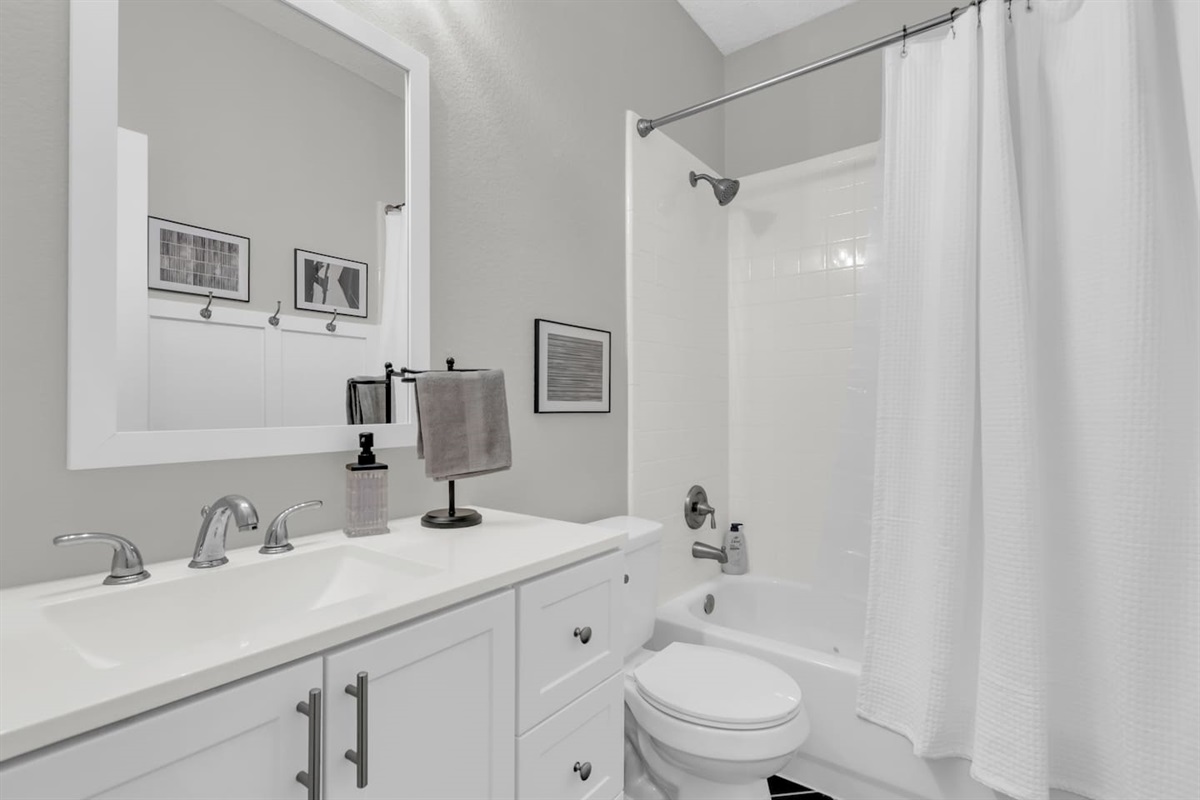 Well-appointed bathroom offering a combo tub and shower, vanity, modern finishes, and plenty of space for getting ready.
