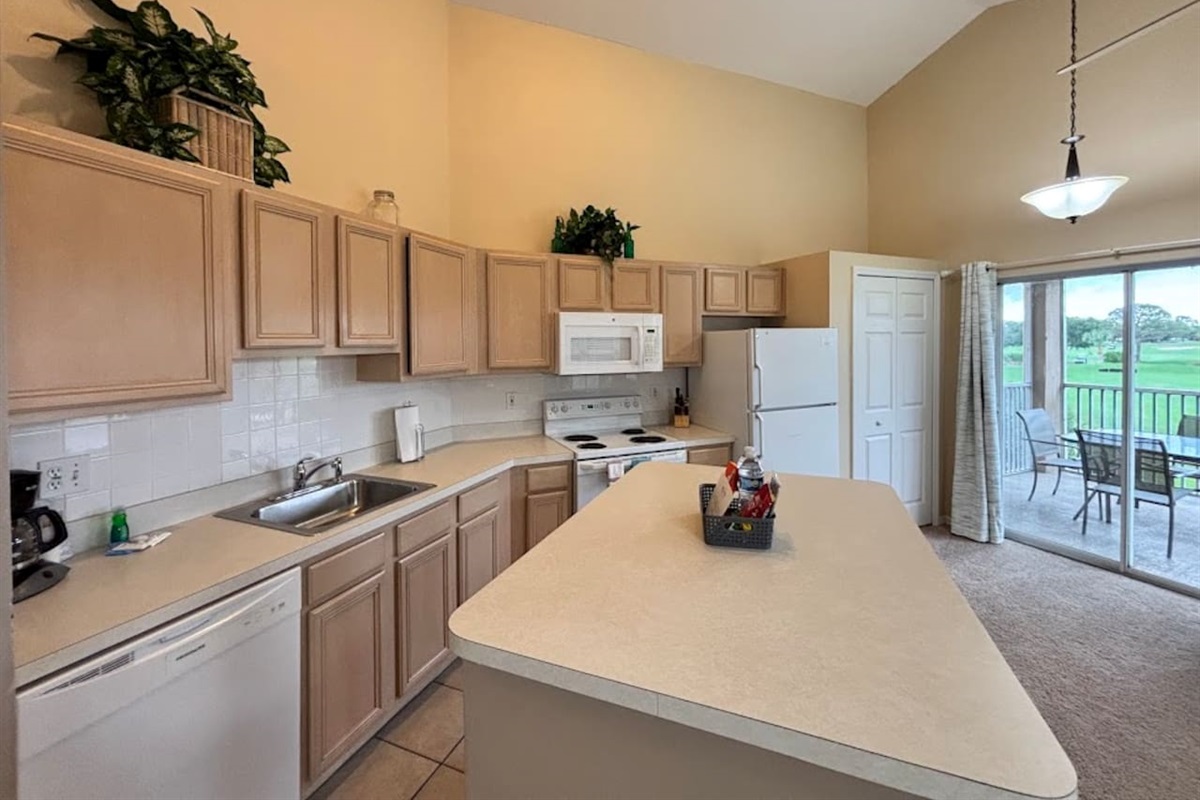Fully equipped kitchen with plenty of cabinet space, full-size appliances, breakfast bar, and an open layout.