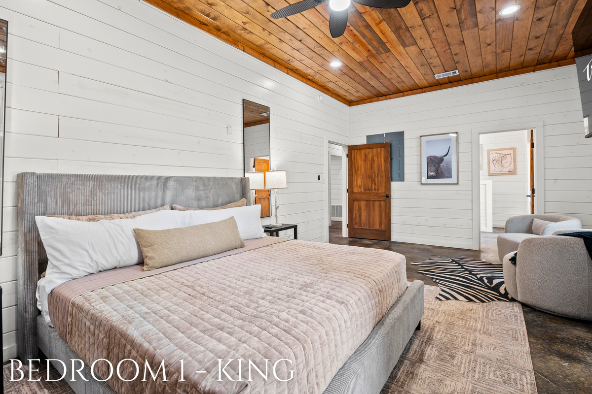 A peaceful king suite with warm wood tones, plush bedding, and a cozy seating area for unwinding in comfort.