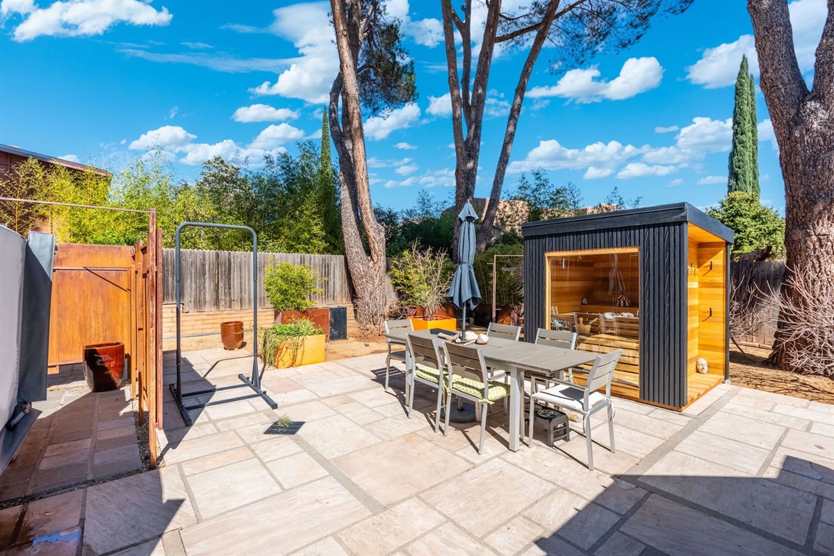 Private outdoor oasis featuring a modern sauna, open-air shower, and spacious patio with dining area — the perfect setting to relax, recharge, and enjoy the sunshine.