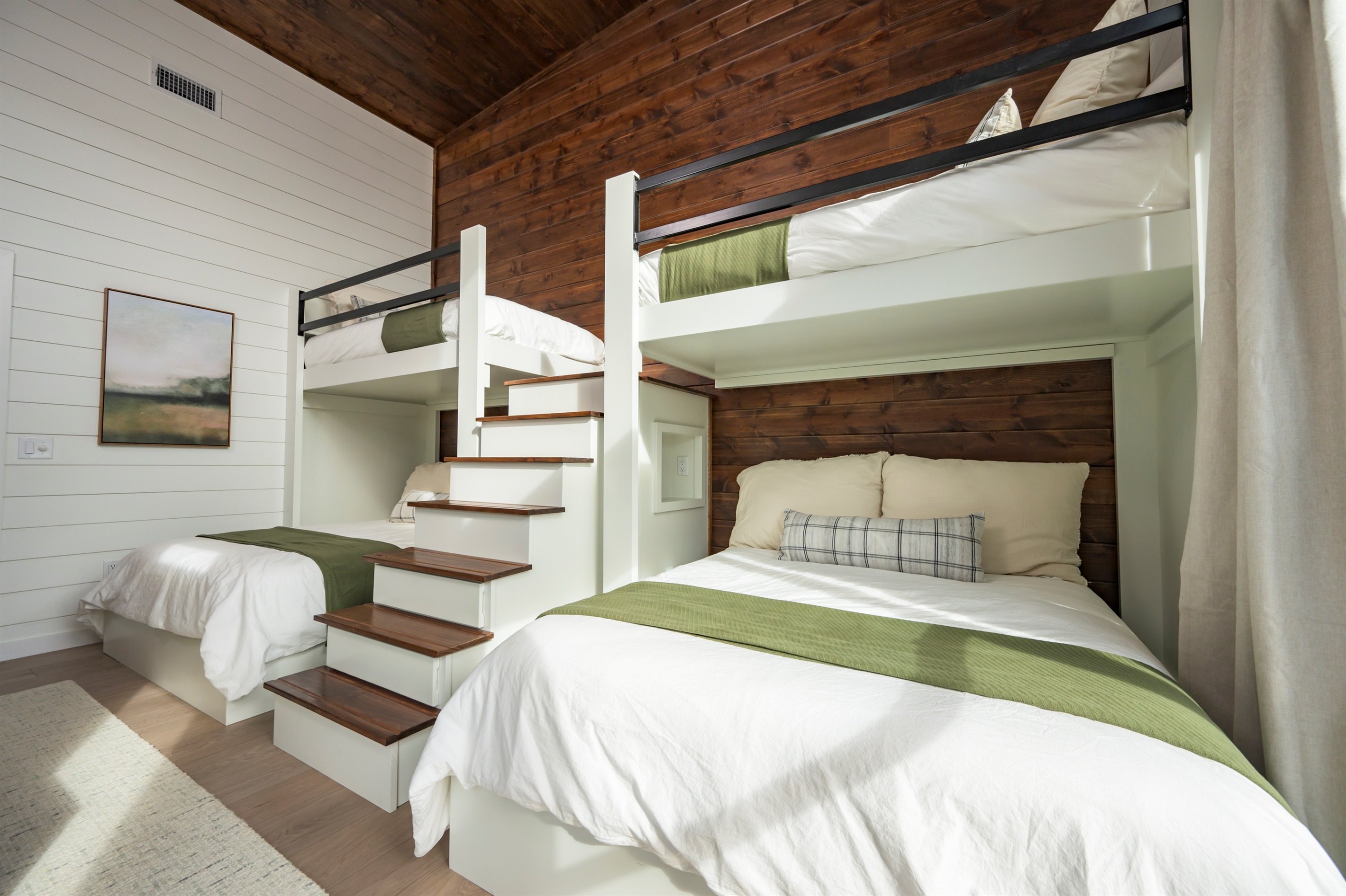 Bunk room with 2 bunk-bed units: 2 single/twin mattresses on top and 2 queen mattresses on the bottom (4 beds total). Sleeps 6. Cedar wood finishes, smart TV, and luxurious linens.