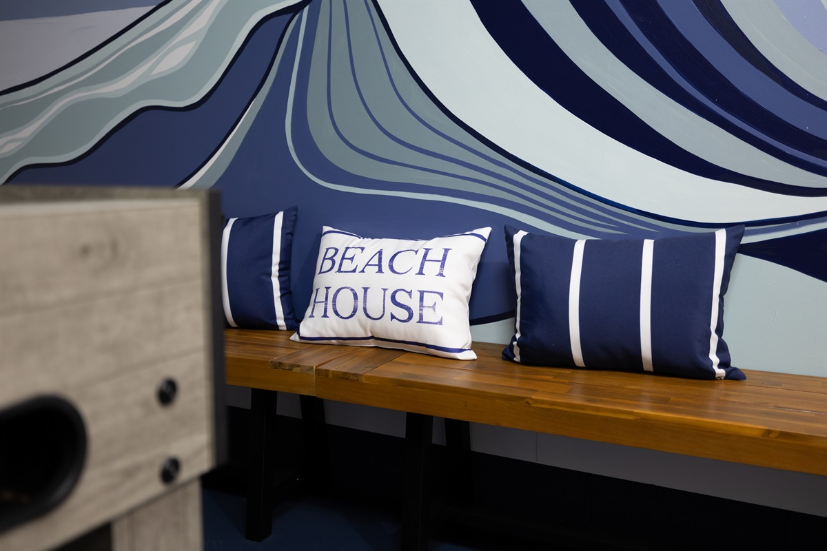 Where beach vibes meet friendly competition 🌊
Kick back on the built-in bench beneath our custom Jacksonville Beach mural &mdash; the ultimate hangout space for all ages.