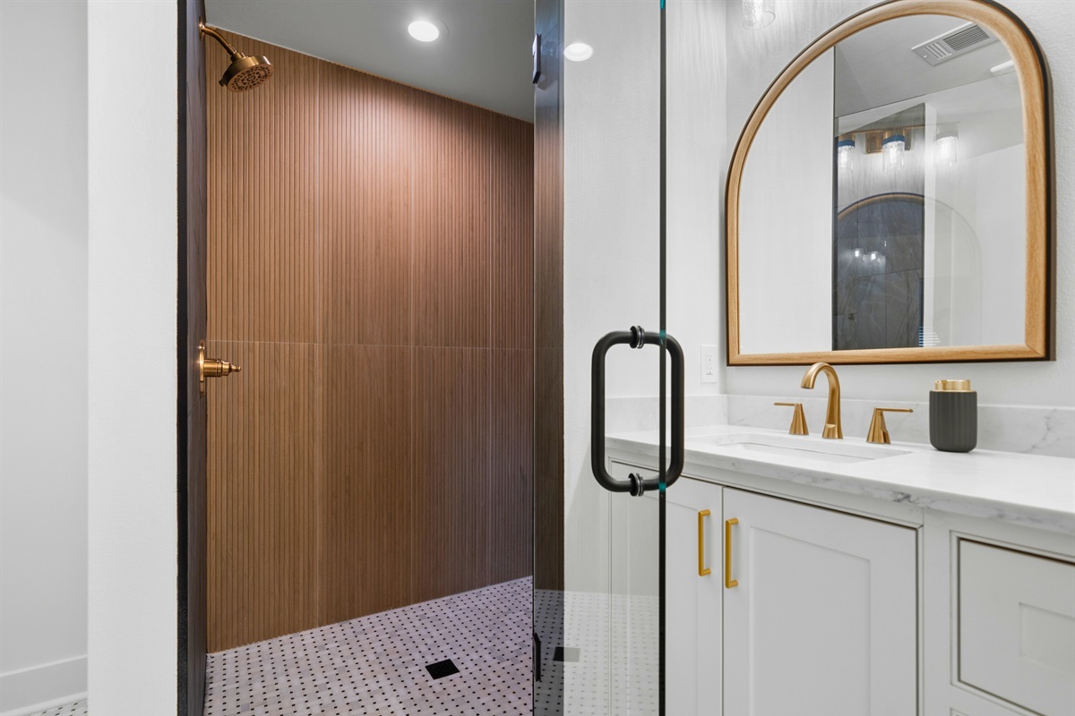 A closer look at this well-appointed bathroom offers a modern vanity and spacious shower for added convenience.