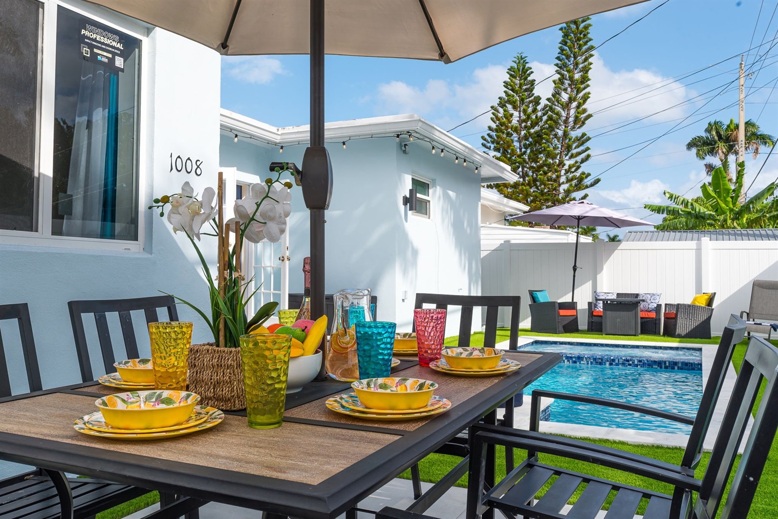 Enjoy al fresco dining by your private heated pool in this sunny Florida backyard, complete with vibrant outdoor seating and lush tropical vibes.