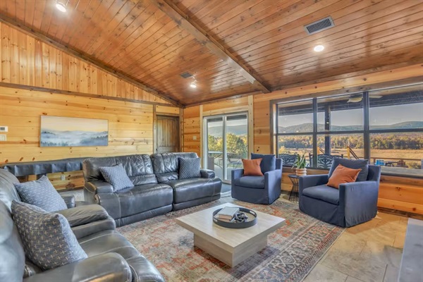 Spacious living room with plush seating and large windows overlooking the valley.