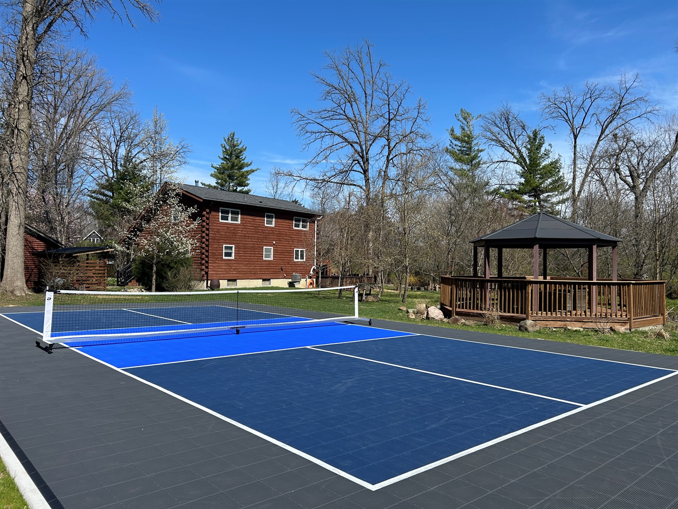 Private onsite regulation size pickleball court with Sport Court surface.