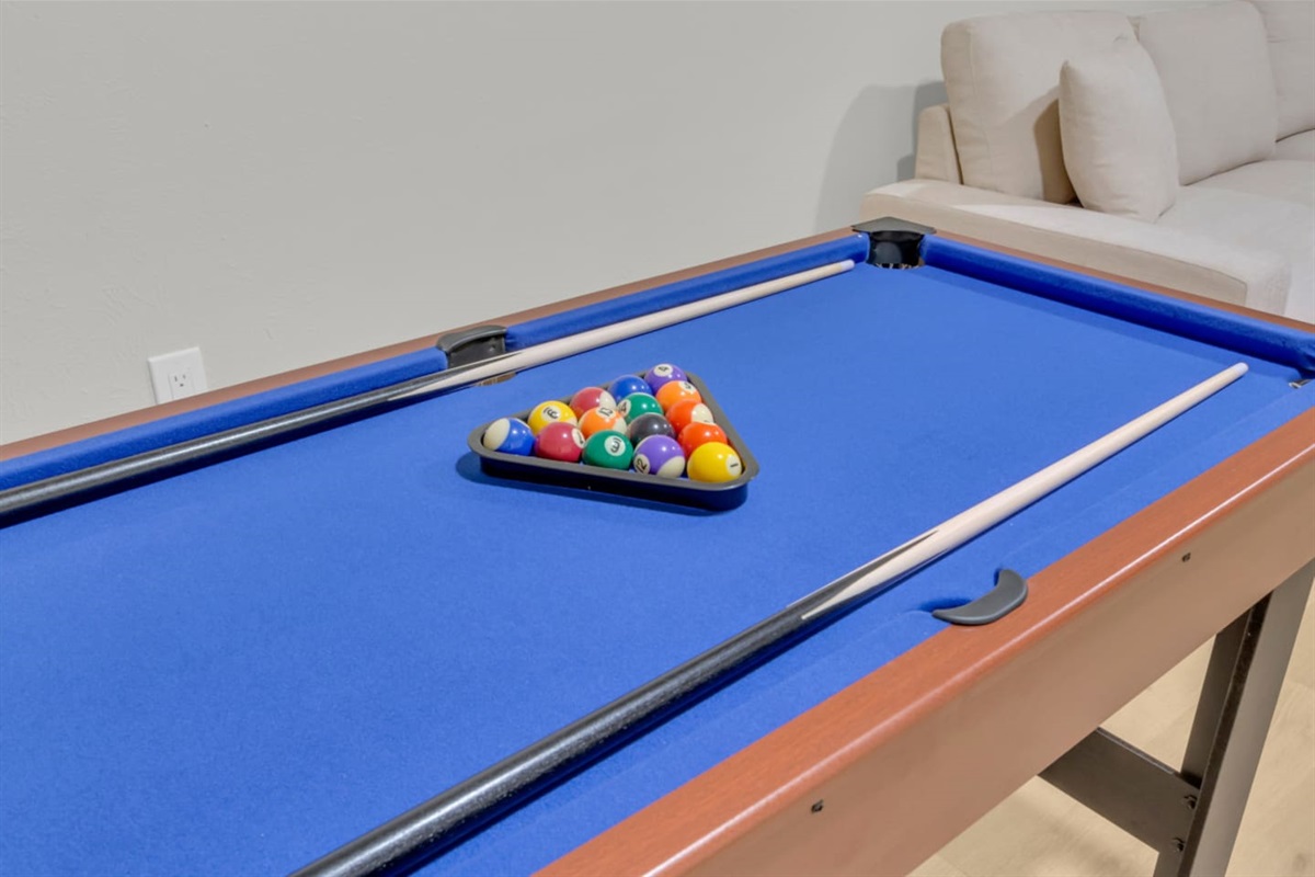Classic pool table with full cue and ball set, ready for friendly competition. A fun highlight of the home’s indoor entertainment amenities.