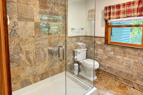 Bathroom with wide tiled shower and frame-less glass surround
