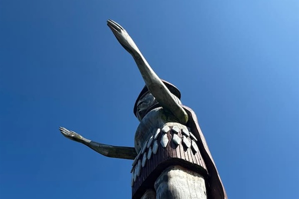 Skwxwú7mesh (Squamish) Welcome figure at Ambleside Beach nearby in carved red cedar