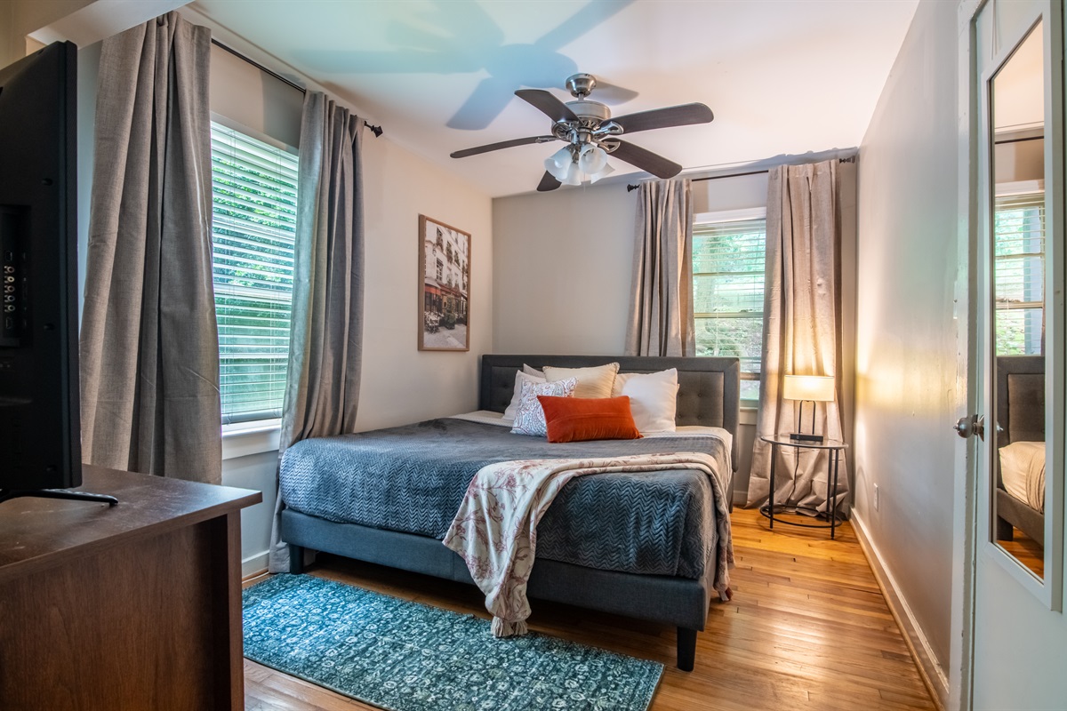 Comfortable Suite bedroom with stylish linens, bedside lighting, and soft, natural light for a relaxing stay.