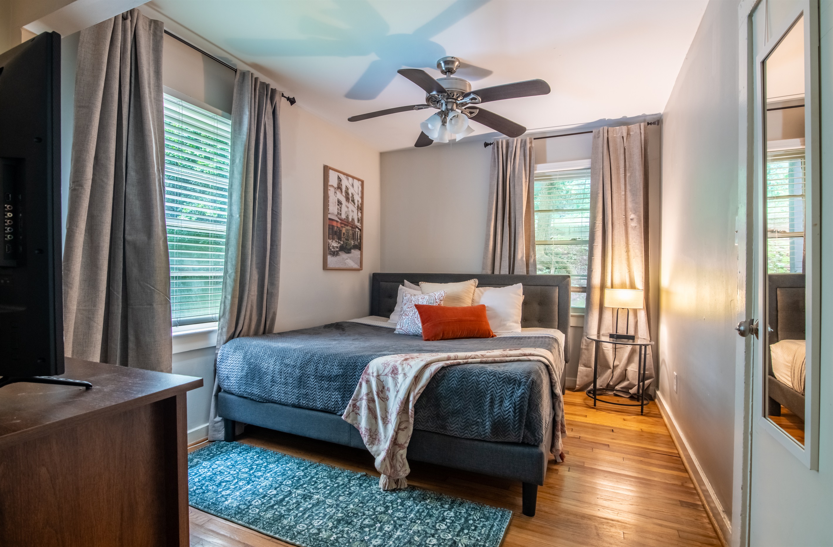 Comfortable Suite bedroom with stylish linens, bedside lighting, and soft, natural light for a relaxing stay.