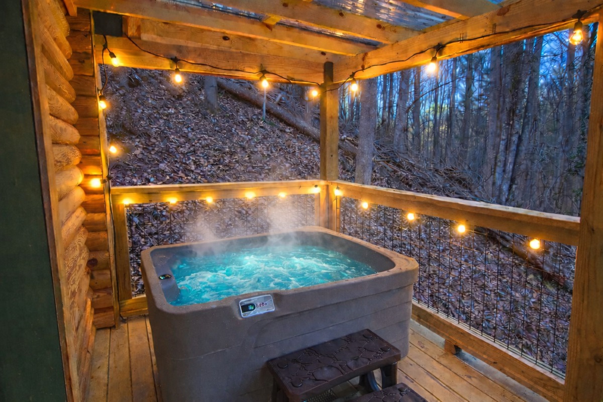 Soak under the string lights in your private, steamy mountain escape Unwind in the hot tub as the forest surrounds you — pure relaxation, day or night.