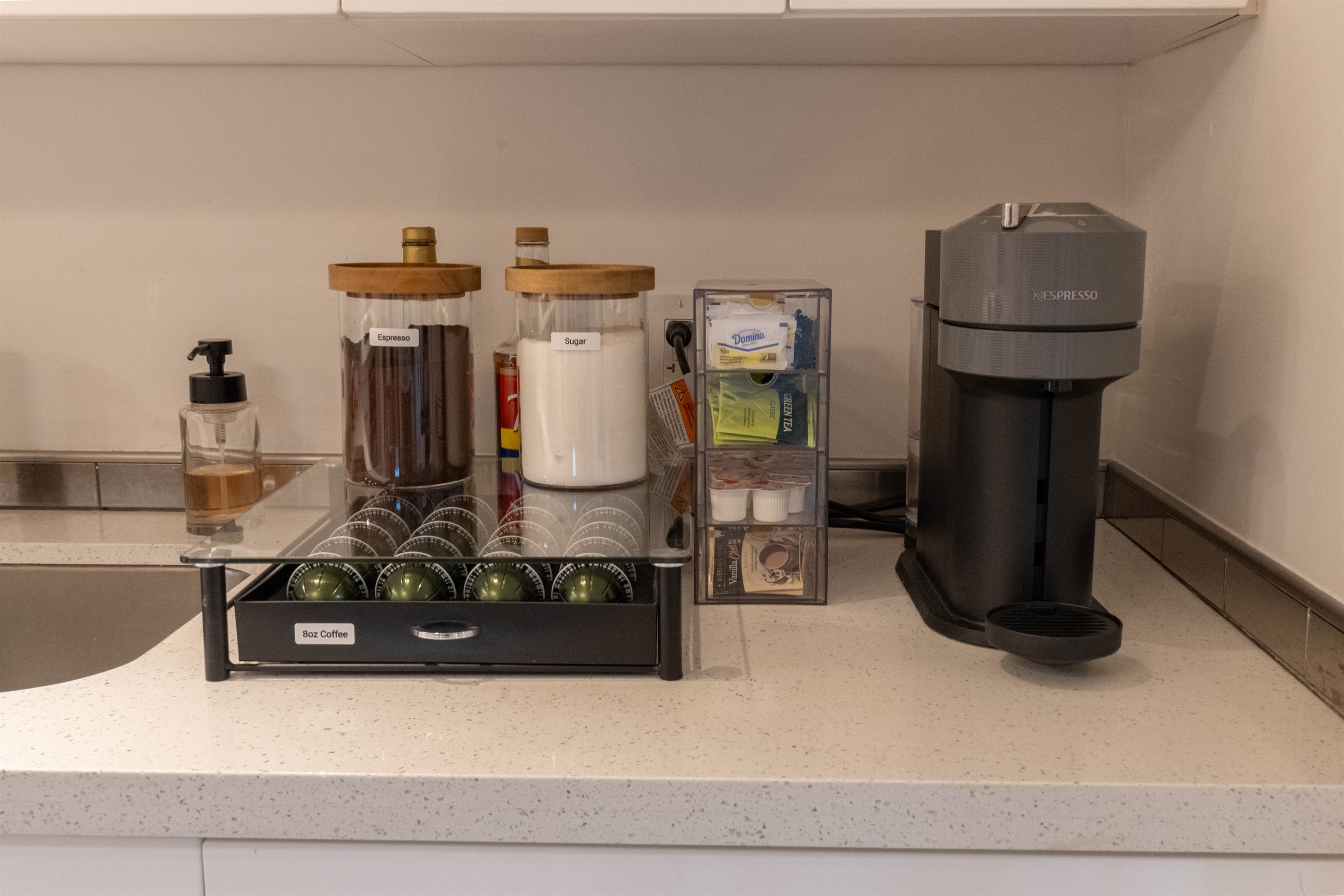Coffee bar with Nespresso machine, pods, tea, and sweetener options
