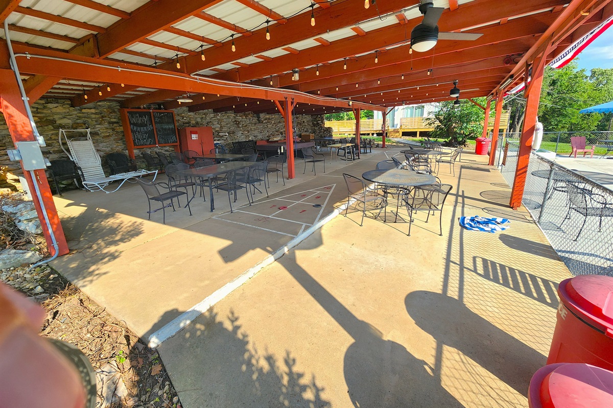 Pavilion View #1. Features ceiling fans, gathering tables, fun lighting, pool table, ping pong table, shuffleboard, a TV, roll down shades, more!