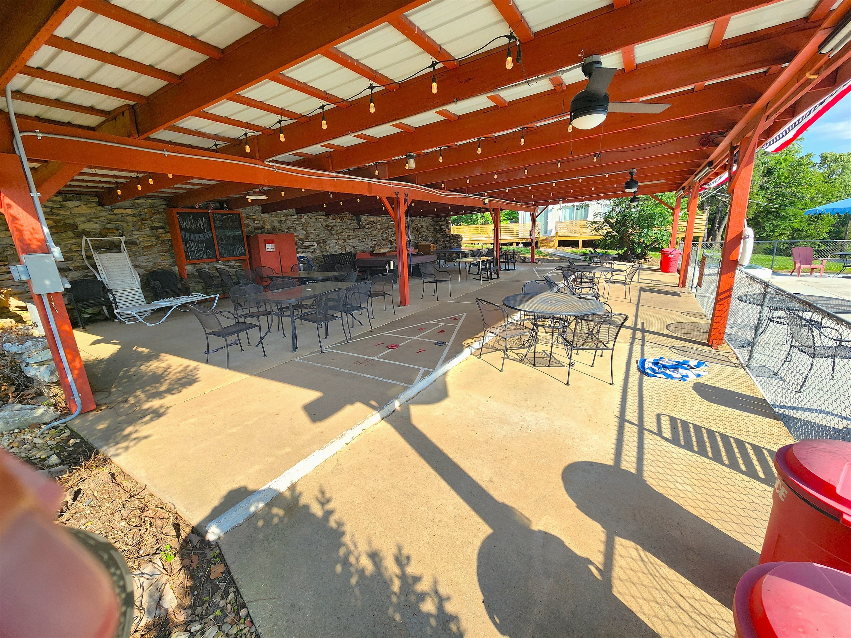 Pavilion View #1. Features ceiling fans, gathering tables, fun lighting, pool table, ping pong table, shuffleboard, a TV, roll down shades, more!
