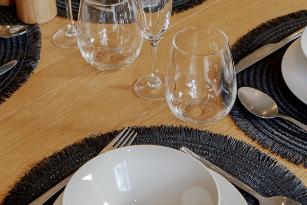The dining table is set with bowls, plates and glassware, giving Fernhill Mountain Escape an easy shared-meal setup.