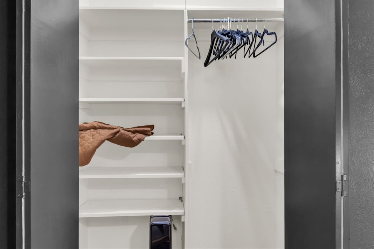 Closet equipped with hangers and a spare blanket, offering convenient storage and added comfort during your stay.