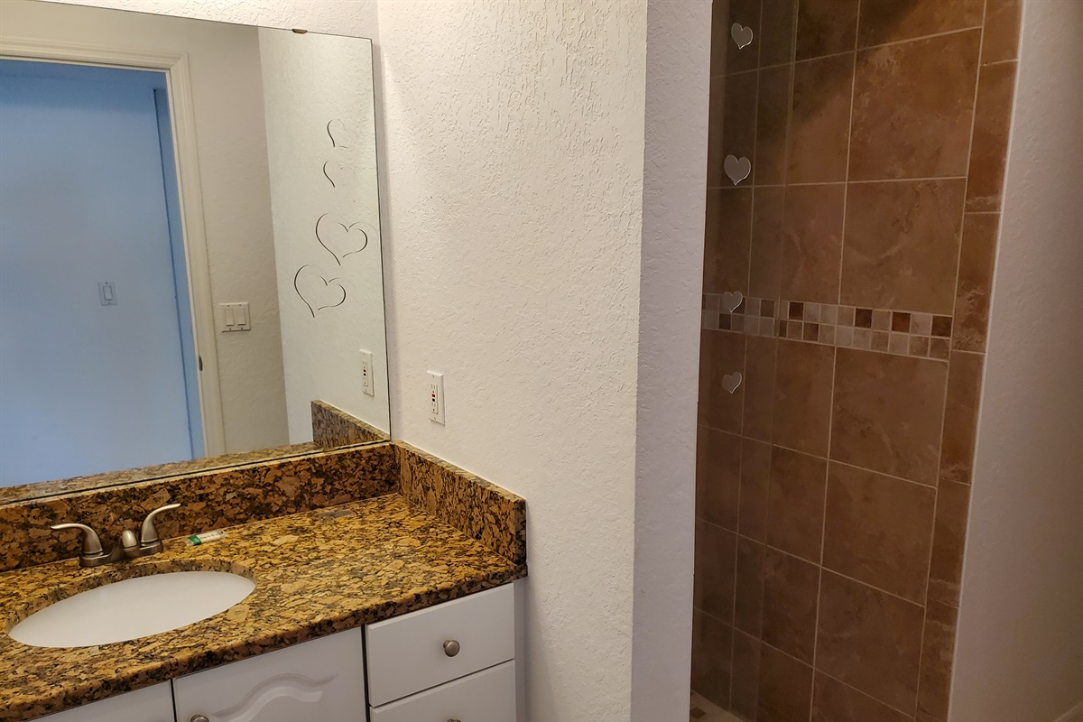 Twin bedroom private bathroom with walk in shower, sink and toilet