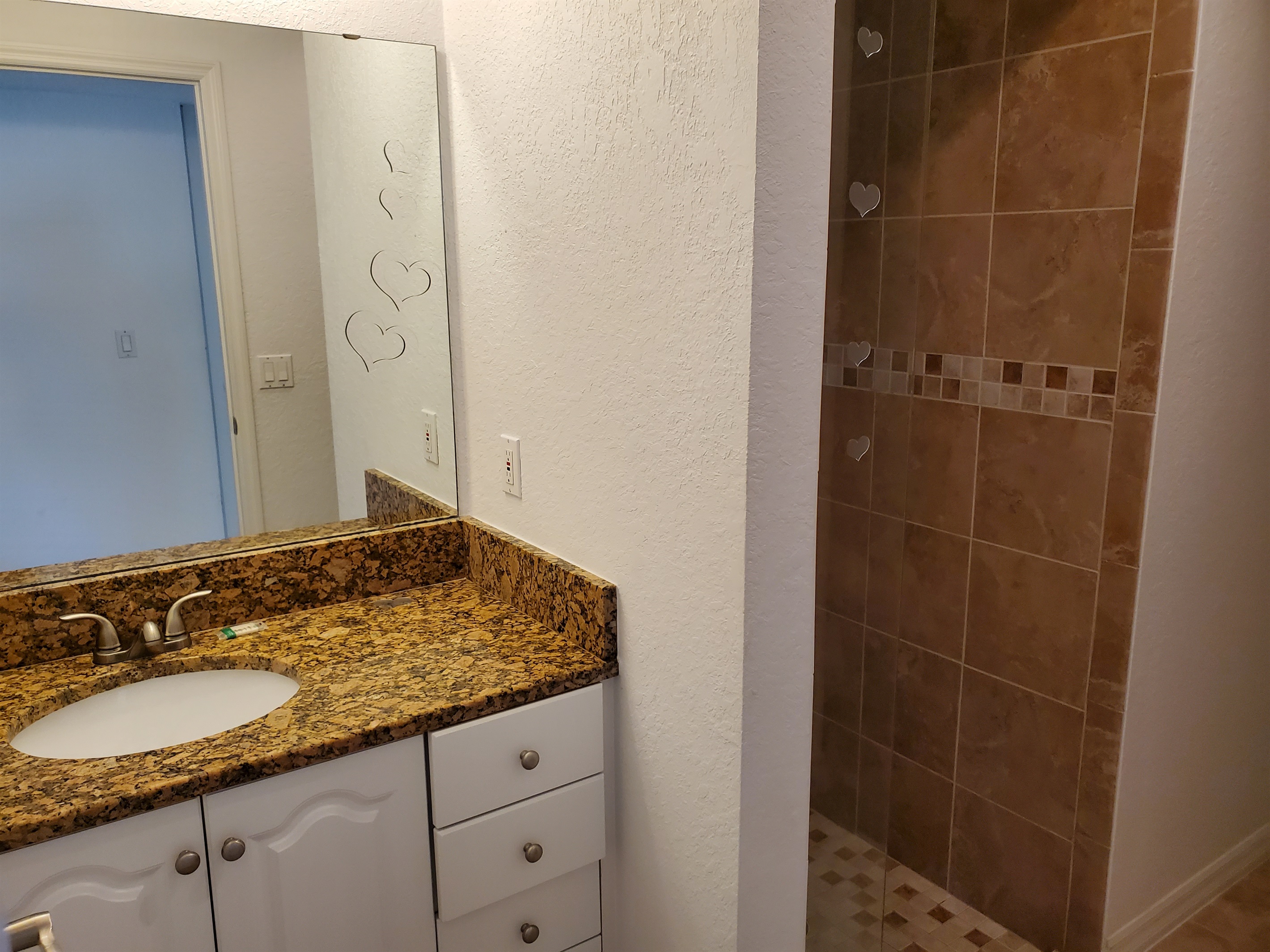 Twin bedroom private bathroom with walk in shower, sink and toilet