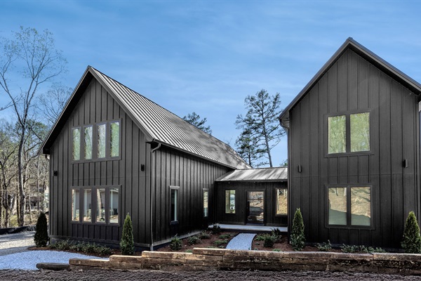 A bold modern retreat with timeless charm—Sunset Cove’s sleek black exterior welcomes your group to a peaceful lakefront escape.