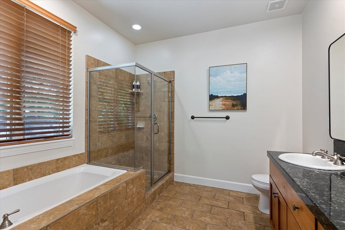 A spacious full bathroom featuring a soaking tub, walk-in shower, and double vanity—designed for both convenience and comfort.