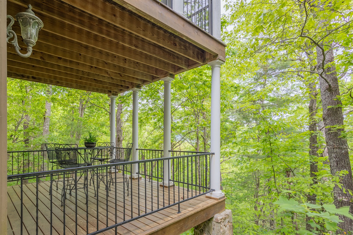 Relax on the covered lower-level deck surrounded by peaceful wooded views and fresh mountain air.