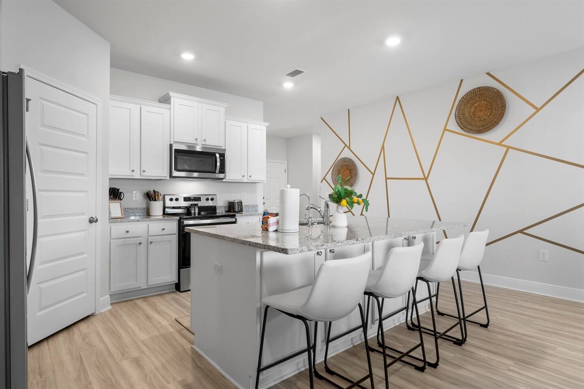 Modern full kitchen with a breakfast bar, 4 bar stools, and top-of-the-line appliances.