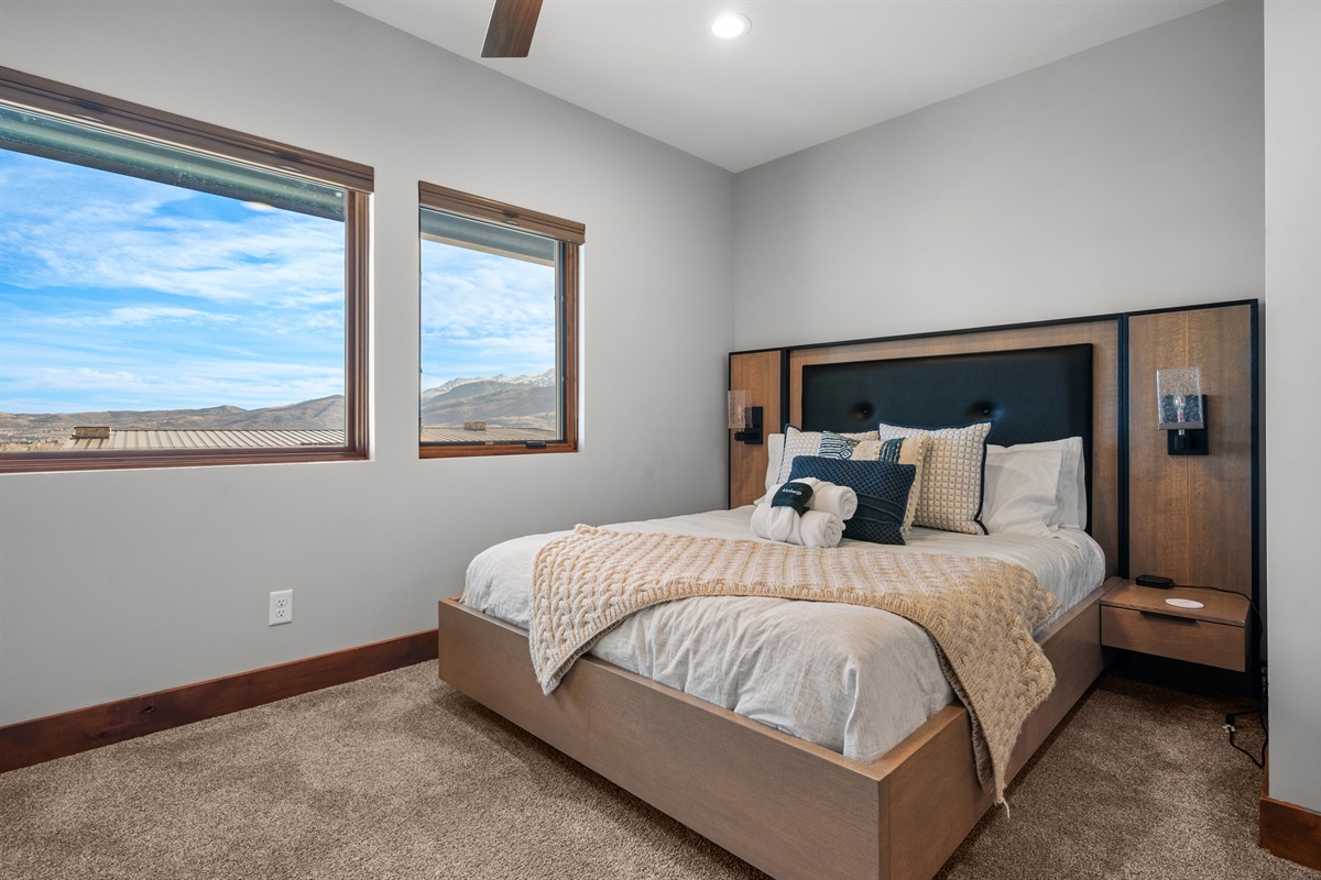 The second bedroom is outfitted with a queen bed, luxurious linens, and plush pillows. It has an ensuite bathroom and is located on the lower level.