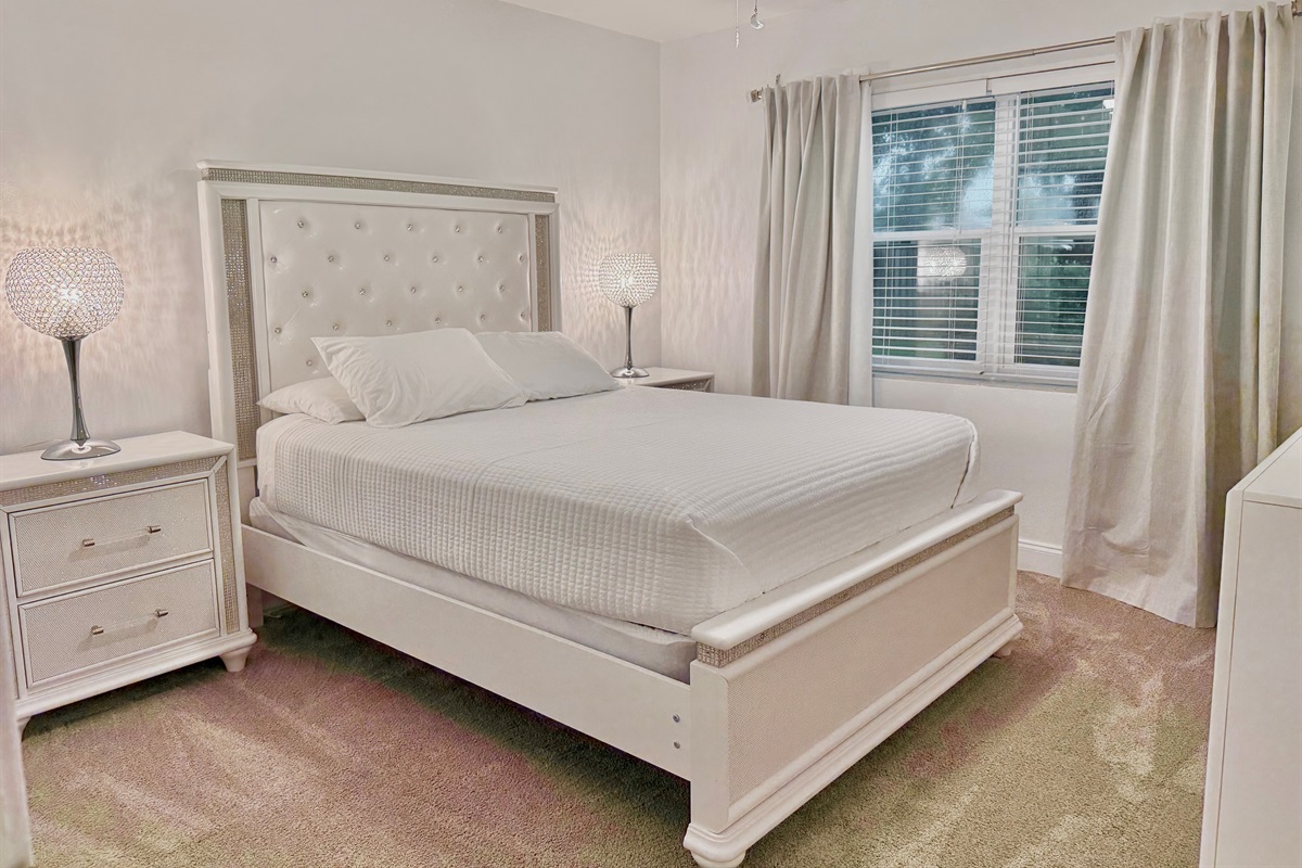 Drift off in this peaceful bedroom oasis, featuring rich textures, soft bedding, and plenty of natural light.
