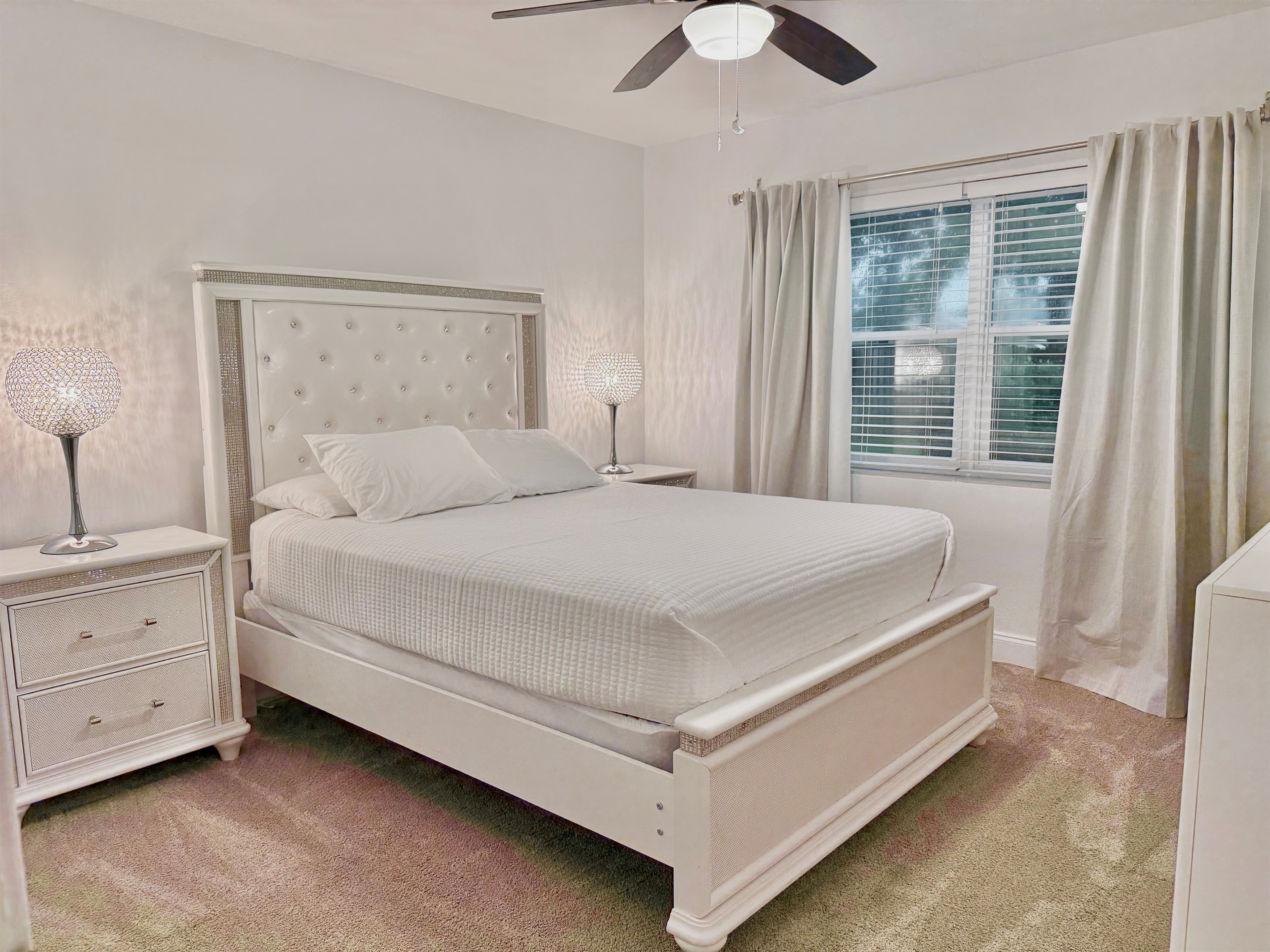 Drift off in this peaceful bedroom oasis, featuring rich textures, soft bedding, and plenty of natural light.