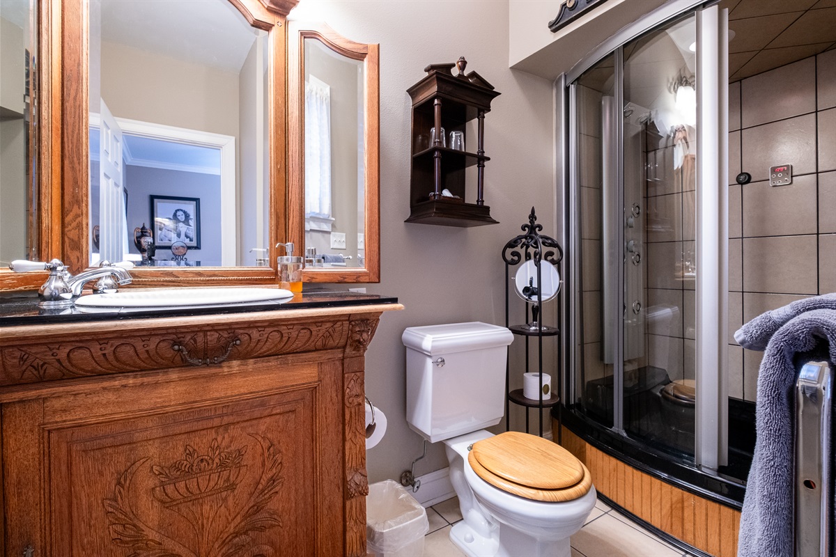 Private en-suite bathroom with walk-in shower, custom wood vanity, and polished fixtures.