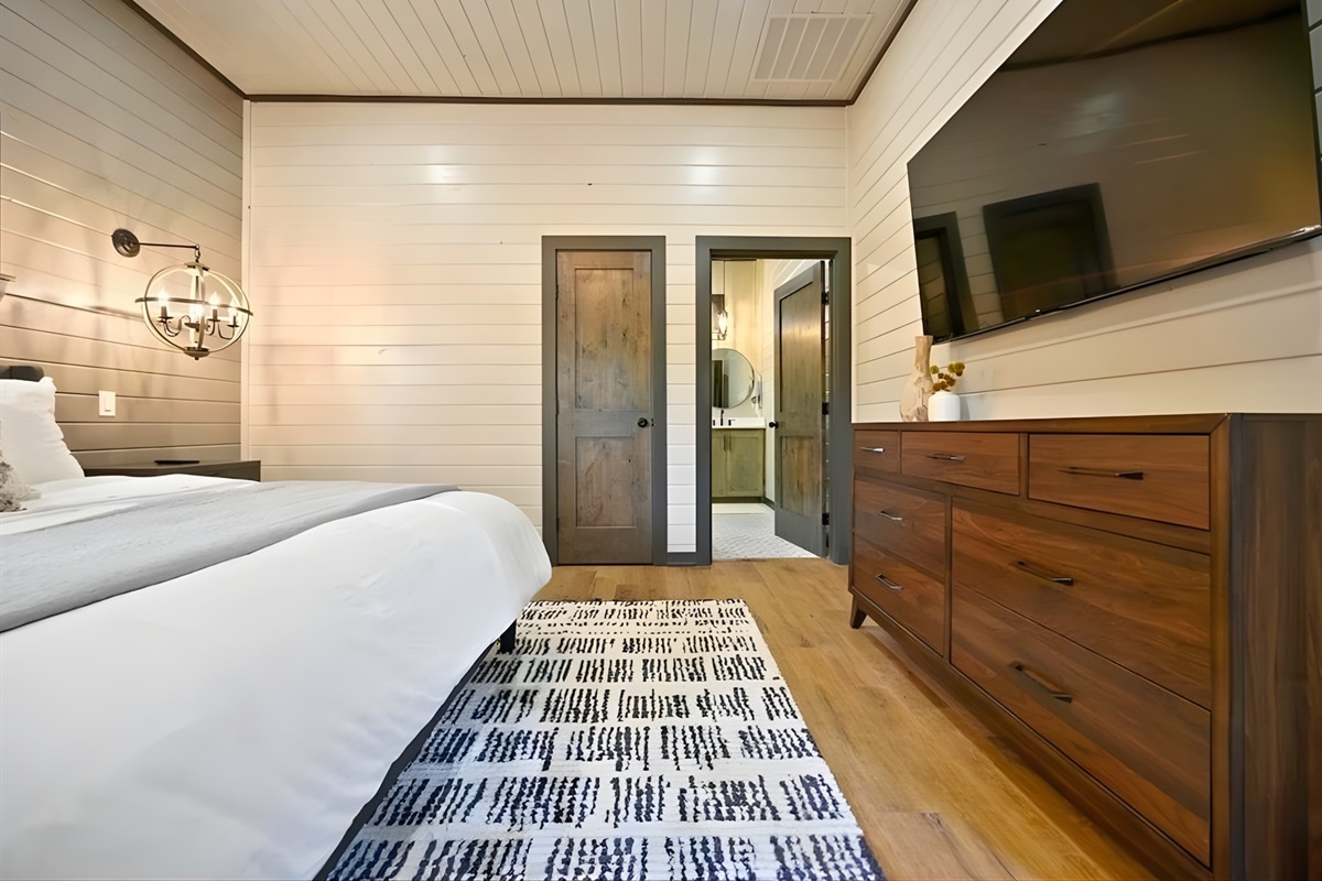 Warm wood accents and soft textures create a bedroom that feels both cozy and elevated.