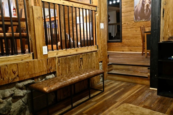 Step inside and settle in—your entryway features a stylish leather bench for kicking off boots, handy hooks for coats, and cozy cabin vibes with charming moose art to welcome you home.