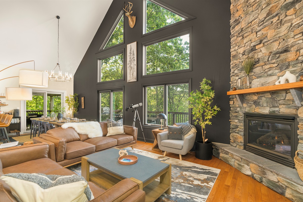 Vaulted ceilings, forest-framing windows, and a bold stone hearth — the great room where style meets serenity