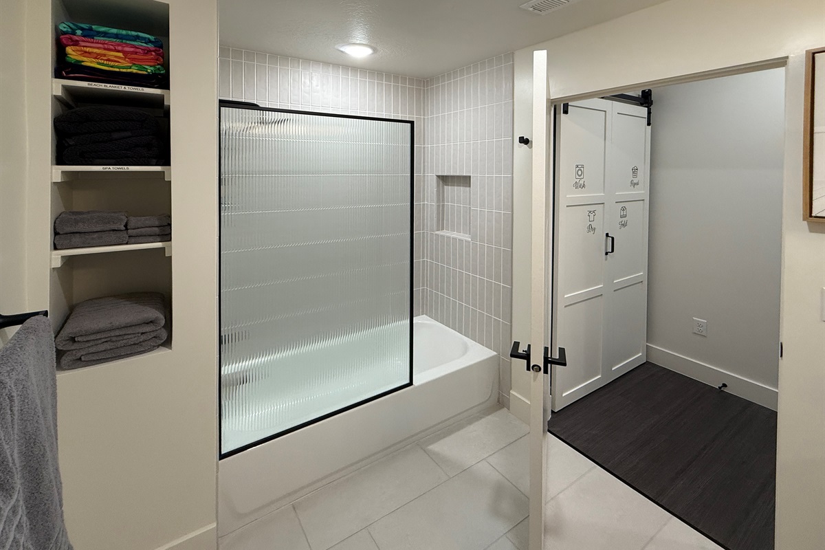 Experience the spacious tub and shower combo enclosed with a sleek glass door.